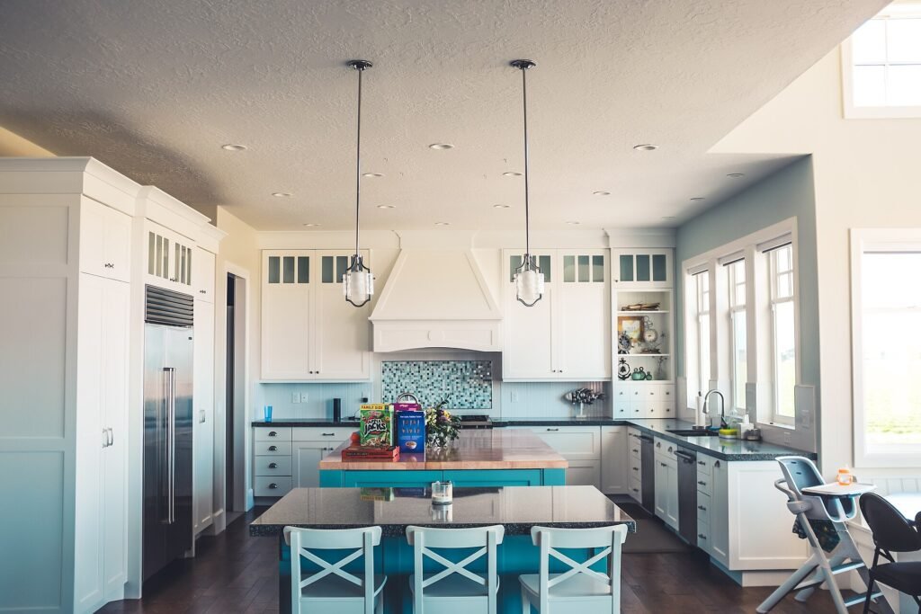 Modern white modular kitchen with island counter and tall storage units